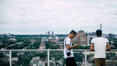 两个男人站在阳台上俯瞰多伦多的城市景色。